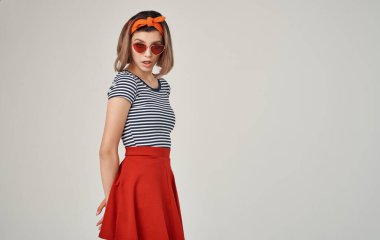 Güneş gözlüğü takan güzel bir kadın. Çizgili tişört, modern moda.