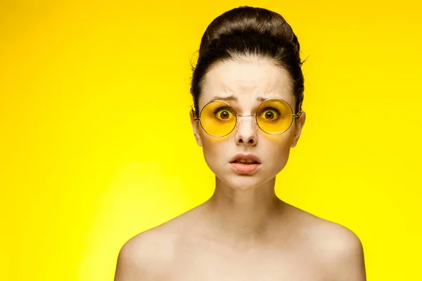 Çıplak omuzlu güzel bir kadın. Sarı gözlüklü. Duyguları keskin. — Stok fotoğraf