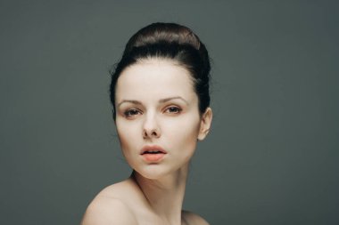 Çıplak omuzlu, çekici görünümlü, izole edilmiş bir arka plan.