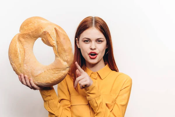 明るい背景とファッショナブルな服の上にパンのパンのローフを持つ美しい女性明るいメイククロップドビュー — ストック写真