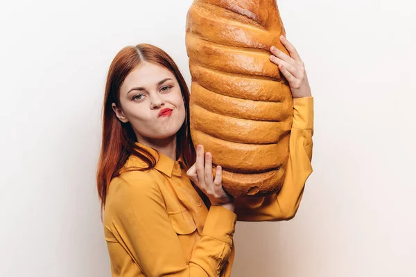 Donna con una pagnotta in mano su uno sfondo leggero emozioni modello divertimento — Foto Stock