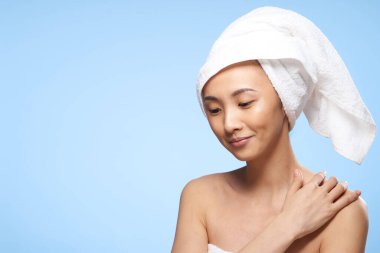 Güzel bir kadın çıplak omuzlar Asyalı görünüm havlusu mavi arka planda