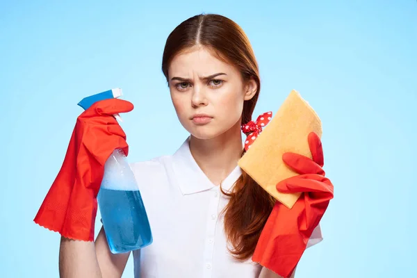 Mujer con suministros de limpieza en las manos de la entrega de servicios profesionales fondo azul — Foto de Stock