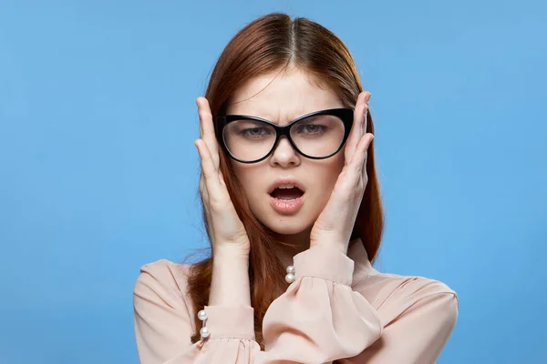 Mujer bonita elegante estilo gafas moda emociones manos cerca de la cara fondo azul — Foto de Stock