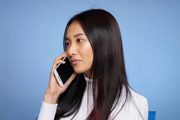 Mujer asiático apariencia hablando en el teléfono tecnología estudio azul fondo — Foto de Stock