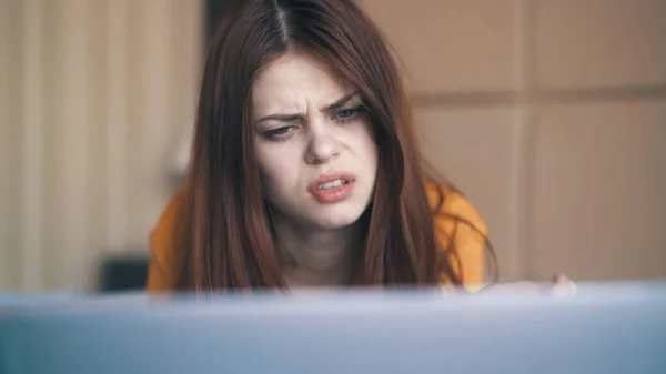 Emotional woman lies in bed in front of laptop freelance discontent — Stock Photo, Image