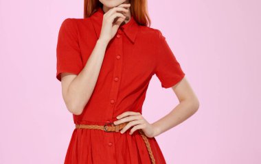 Pembe arka planda kırmızı elbiseli güzel bir kadın. Kopyalama alanı.