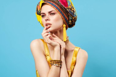 çekici bir kadın parlak makyaj dekorasyonu etnik köken çok renkli türban stüdyosu mavi arka plan