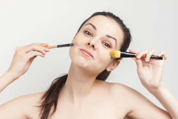 Mulher aplicando pincel de maquiagem no rosto cuidados com a pele — Fotografia de Stock