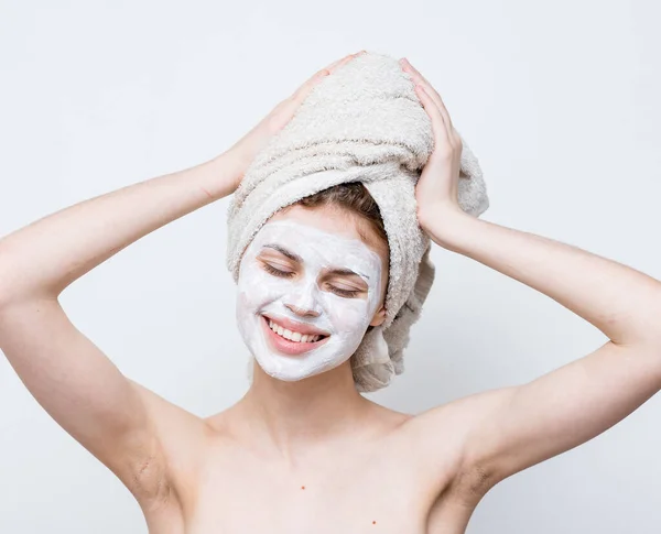 Wanita cantik dengan bahu telanjang wajah krim handuk di kepala kulit bersih — Stok Foto