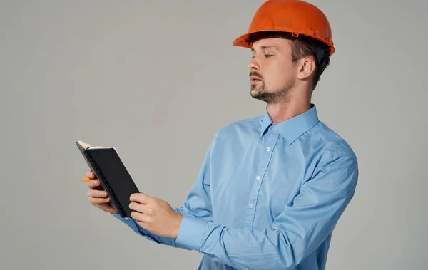 Civil engineer in orange hard hat holding documents in hands notepad business work — Stock Photo, Image