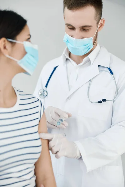 Médecin masculin en manteau blanc faire une injection dans la main d'une femme patient vaccination covid — Photo