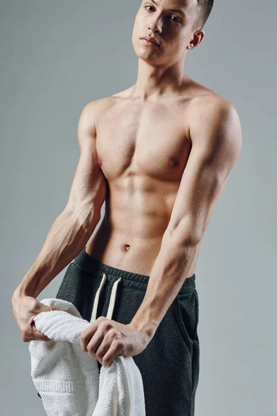 Uomo sportivo con asciugamano in mano pompato stampa allenamento isolato sfondo studio — Foto Stock