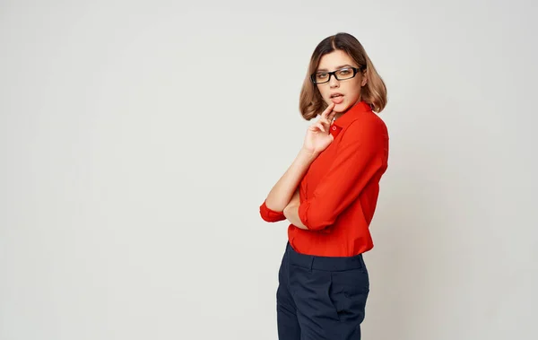 Mulher de negócios em uma camisa vermelha calças azuis e óculos em um fundo bege Copiar Espaço — Fotografia de Stock