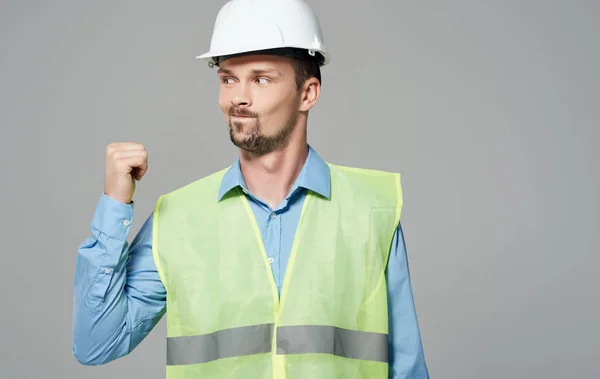 Trabalhador da construção em capacete branco e colete reflexivo verde — Fotografia de Stock