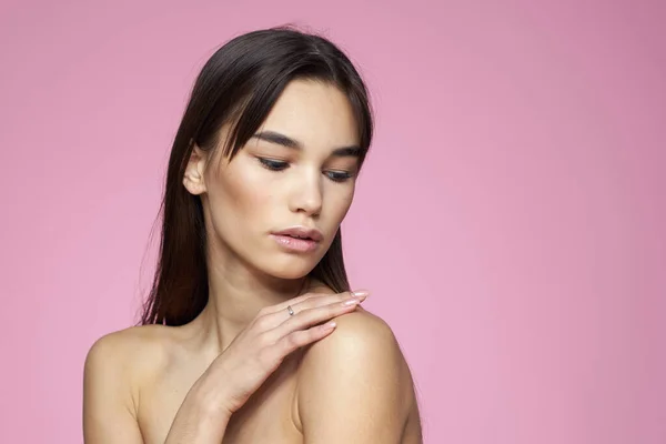 Kobieta z gołymi ramionami pielęgnacja włosów makijaż czysta skóra różowy tło — Zdjęcie stockowe