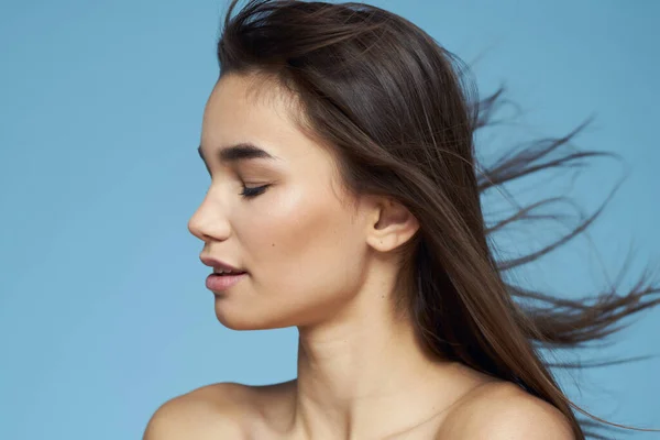 Mulher bonita ombros nus cuidados com o cabelo close-up banco azul fundo — Fotografia de Stock