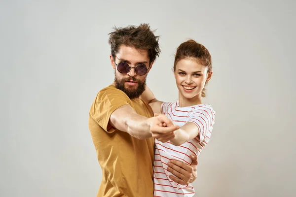 Muž v slunečních brýlích vedle ženy v pruhovaném tričku emoce komunikace módní studio zábava — Stock fotografie