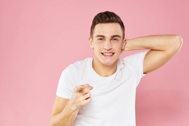 Beyaz tişörtlü neşeli yakışıklı adam duygular pembe soyutlanmış arka plan