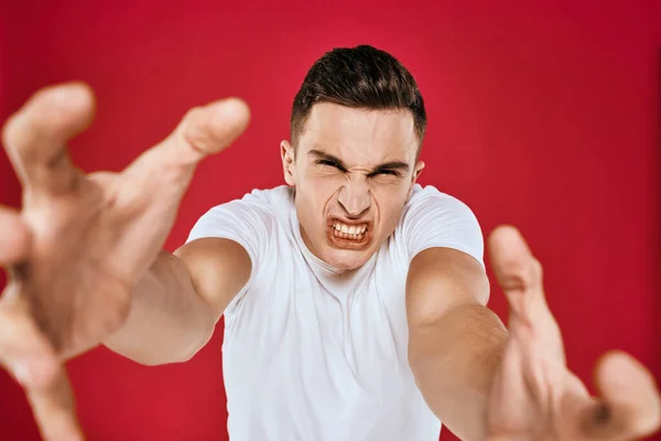 Känslomässig man vit t-shirt missnöjd ansiktsuttryck röd isolerad bakgrund beskärd vy — Stockfoto