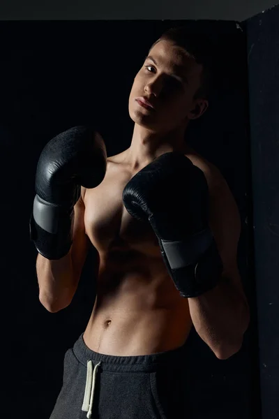 Atlet v boxerských rukavicích na černém pozadí portrét oříznutý pohled — Stock fotografie