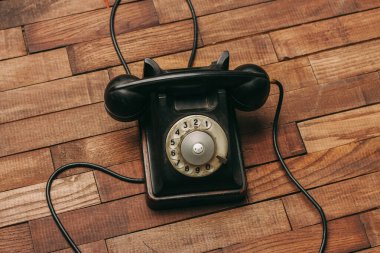 Teknolojinin klasik ahşap zemininde siyah retro telefon.