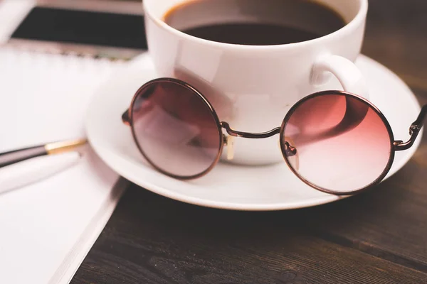 Taza de café en un platillo de madera bloc de notas pluma oficina papelería —  Fotos de Stock