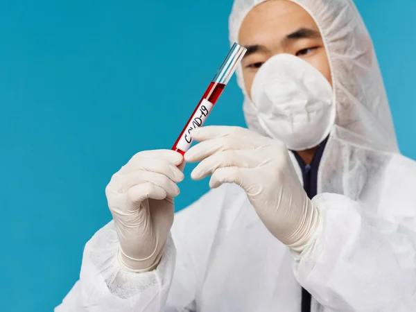 Азіатський чоловічий медичний одяг аналізує діагностику крові на зразок covid-19. — стокове фото