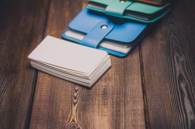 Tahta bir arka planda çok renkli kartvizit tutucuları ve bir paket beyaz kağıt Boşluğu Kopyala