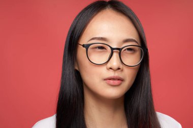 Neşeli, güzel, Asyalı bir kadın. Duygular çekici. Yakın plan kırmızı arka plan.