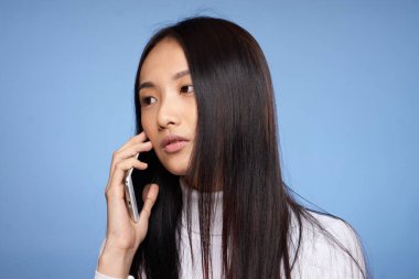 Koyu saçlı, Asyalı bir kadının portresi. Kahve, mavi arkaplan.