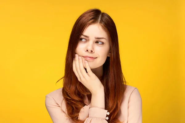 Mulher atraente segurando mão perto de cara charme emoção fundo amarelo — Fotografia de Stock