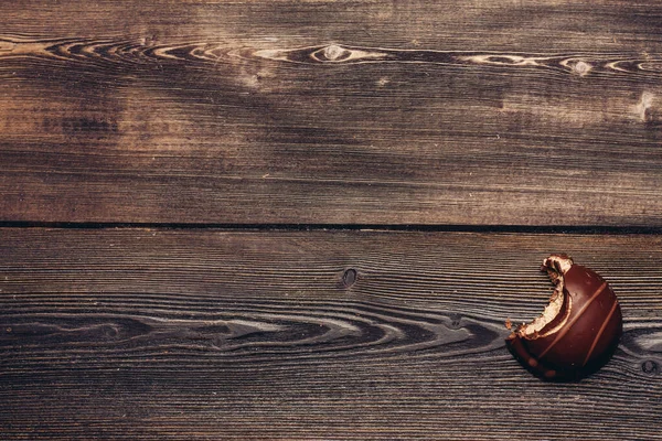 木製の背景のテクスチャにかまれたブラウニーチョコレート — ストック写真