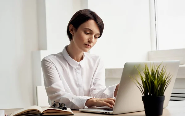 Жінка сидить за робочим столом перед менеджером офісу з фінансування ноутбуків — стокове фото