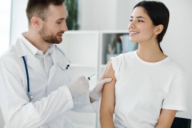 Ampul aşısı olan bir doktor ve mutlu bir hasta sağlığı uzmanı. 
