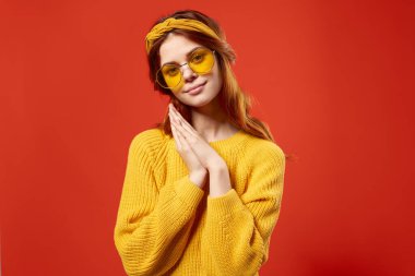 Neşeli kadın hippi sarı süveter gözlüğü duyguları kırmızı arka plan