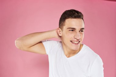 Beyaz tişörtlü bir adam elleri ve duyguları ile jestler yapıyor.