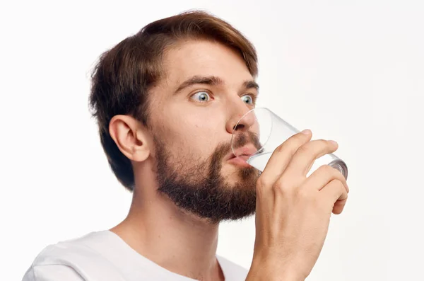 Homem bonito beber água de um copo surpreendido olhar emoções fundo branco — Fotografia de Stock