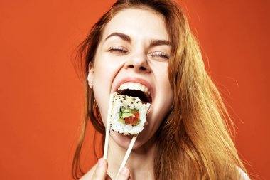 Neşeli kızıl saçlı kadın sushi diyet yapıyor. Yakın plan eğlence.
