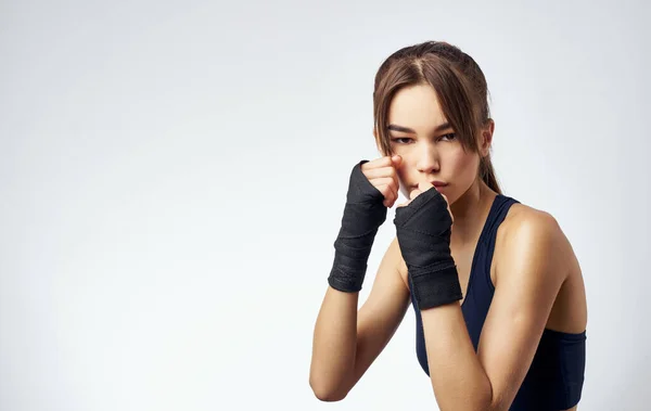 Mujer con mancuernas en la mano sobre fondo claro recortado vista de la camiseta corta fitness — Foto de Stock