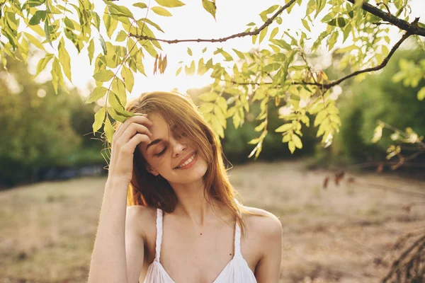 Parktaki yeşil ağaçların yanında beyaz elbiseli romantik kadın. — Stok fotoğraf