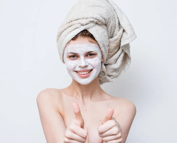 Woman with bare shoulders face cream towel on head — Stock Photo, Image