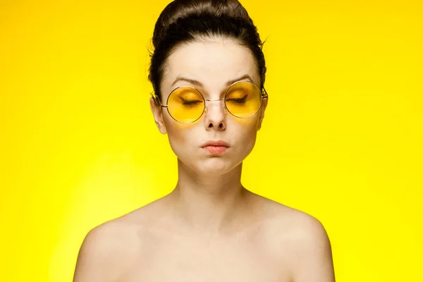 Sarı gözlüklü, çıplak omuzlu, çekici bir kadın. — Stok fotoğraf
