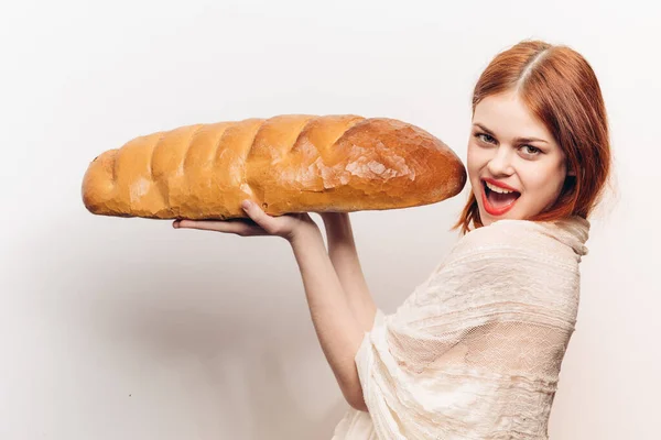Vista lateral da bela mulher ruiva com pão fresco nas mãos — Fotografia de Stock