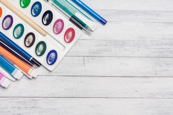 Aquarela pintar marcadores e lápis em uma mesa de madeira vista superior Copiar espaço — Fotografia de Stock