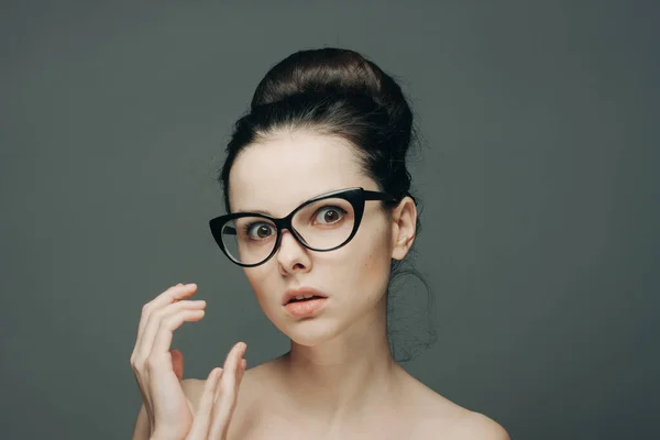 Portrait of beautiful brunette with glasses naked shoulders gesturing with hands — Stock Photo, Image