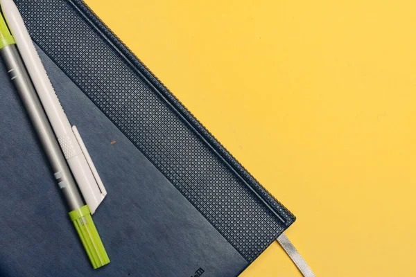 blue notepad and markers pens office yellow green background