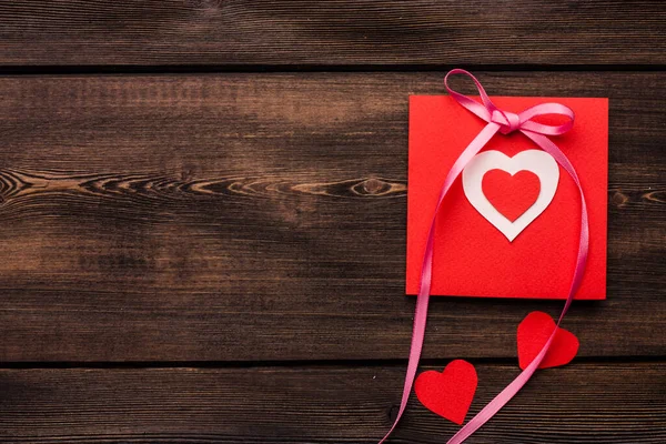 Tarjeta de felicitación con corazón regalo día de San Valentín decoración fondo de madera — Foto de Stock