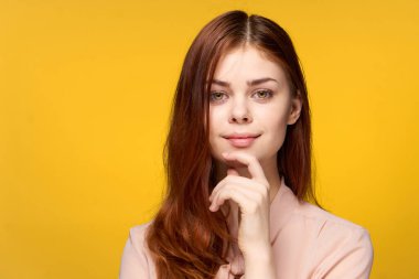 Güzel bir kadın sarı arka plan stüdyo lüks duygularına sahip.