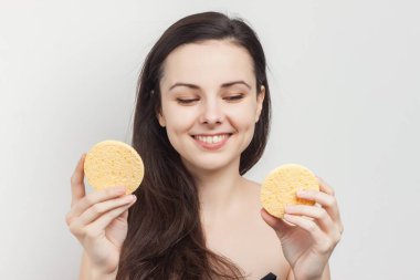 Güzel esmer, gevşek saçlı, temiz tenli, ellerinde süngerler.